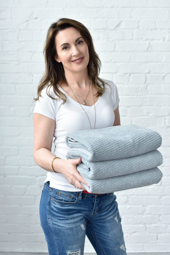 Lori Cela of Time 4 Organizing holding folded towels